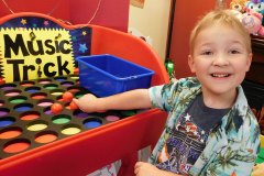 Young child learning music through hands-on color-coded Music Trick toy.